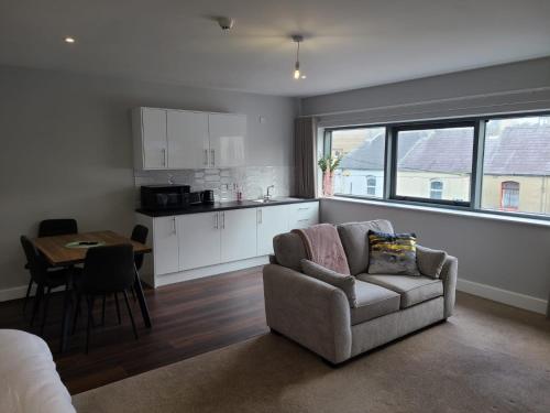 斯莱戈Quay St Apartment的带沙发和桌子的客厅以及厨房。