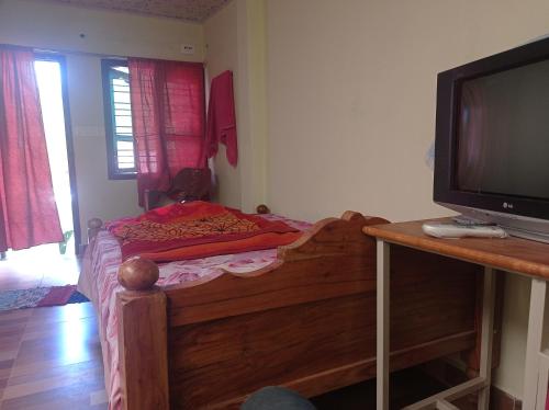 库斯哈尔纳加尔Dreams River view homestay coorg B的一间小卧室,配有一张床和电视