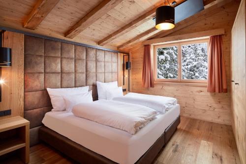 埃尔瓦尔德Zugspitz Lodge的木制客房内的一间卧室配有一张大床