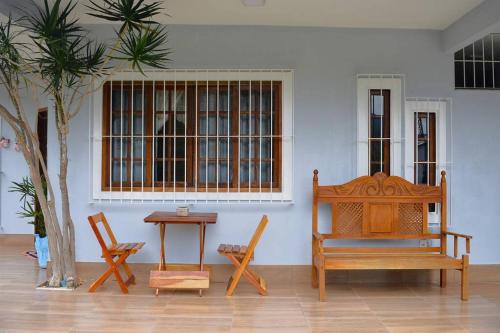 新弗里堡Casa Espetacular no Centro da Serra的一间设有两把椅子、一张桌子和一张长凳的房间