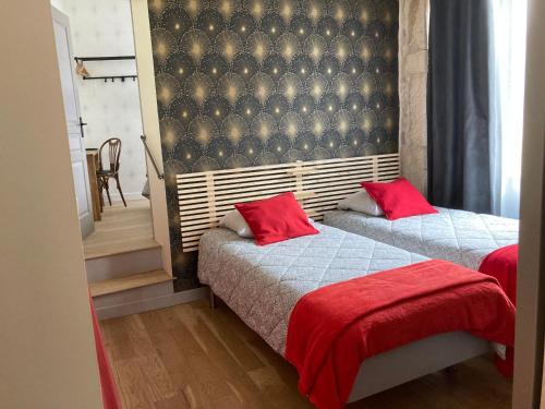 Corcelles-les-ArtsL'Atelier 1的一间卧室配有两张带红色枕头的床
