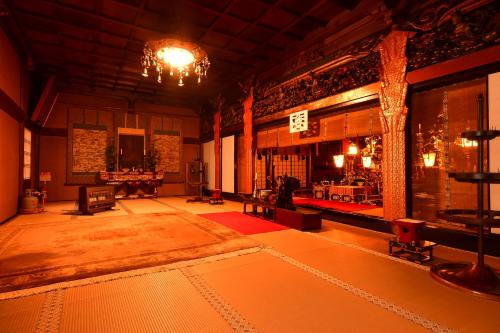 高野山高野山 宿坊 龍泉院 -Koyasan Shukubo Ryusenin-的一间带吊灯的客厅和一间带桌子的大房间