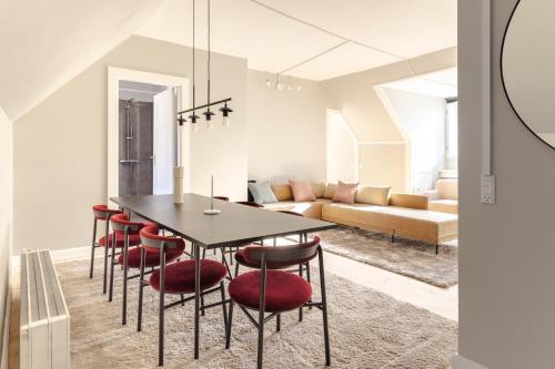 哥本哈根Luxury Apartment w Privat Rooftop Terrace - CPH C的一间用餐室,配有黑桌子和红色椅子