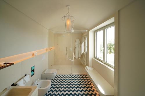 巴科利Dimora dei Lari的一间带水槽和卫生间的浴室以及窗户。