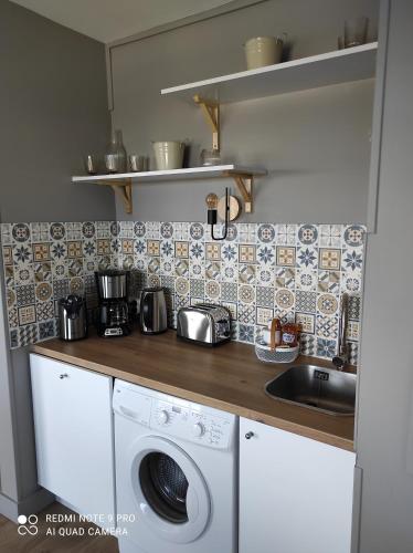 库尔瑟勒·苏尔·梅尔appartement belle vue的厨房配有洗衣机和水槽