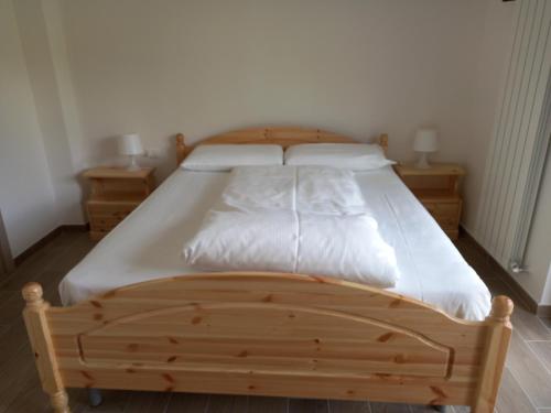 CollebrincioniStrada Facendo的卧室内的木床,带2个床头柜