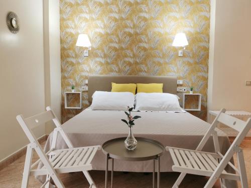 巴尔巴特Hotel Playa del Carmen的一间卧室配有一张带两把椅子和一张桌子的床。