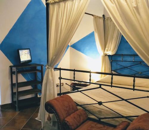 Castel Giuliano阿格里图丽斯莫特努塔蒙特拉瓜迪亚酒店的一间卧室配有一张天蓬床和蓝色的墙壁