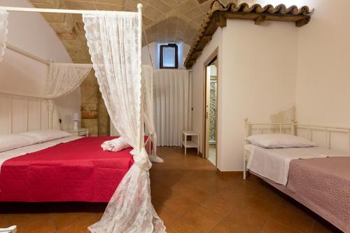 科佩尔蒂诺B&B La Ulia的一间卧室配有两张床和一张天蓬床。