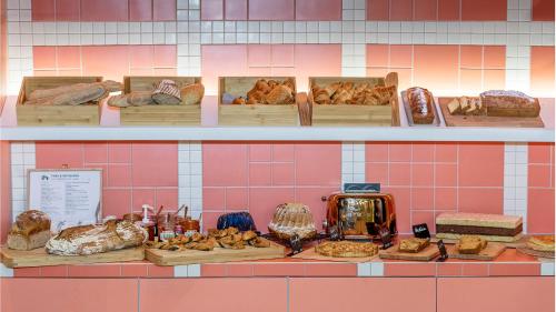 斯特拉斯堡Hôtel Tandem - Boutique Hôtel的储藏着不同种类的面包和糕点的架子
