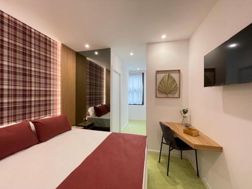波尔图MyStay Porto São Bento的一间卧室配有一张床、一张书桌和一台电视
