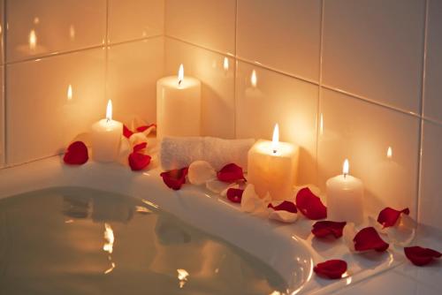 San Antonio火山口乡村民宿的浴室设有浴缸,配有蜡烛和玫瑰花