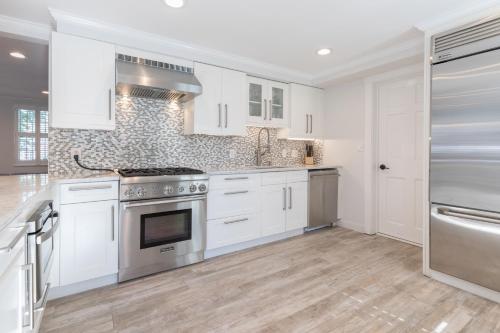 楠塔基特45A Pleasant St的厨房配有白色橱柜和炉灶烤箱。