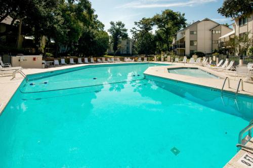 希尔顿黑德岛Springwood Villas II的一个带蓝色水和椅子的游泳池