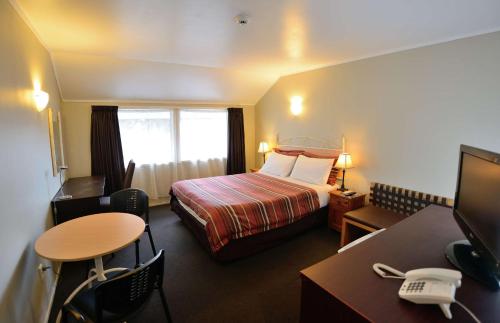 奥克兰萨伊汽车旅馆 - 格林兰奥克兰的配有一张床、一张桌子和一张桌子的酒店客房