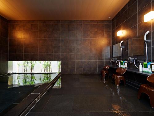 东京新宿歌舞伎町超级酒店的一间带水槽和镜子的浴室
