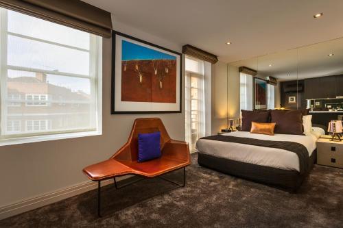 墨尔本奎斯特东墨尔本酒店的一间卧室配有一张床、一把椅子和窗户。