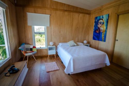 新帕尔米拉Salvaje Punta的卧室配有一张床,墙上挂有绘画作品