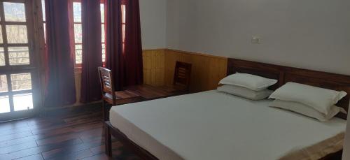 RohruRansaar Valley Homestay的一间卧室配有带白色床单和枕头的床。