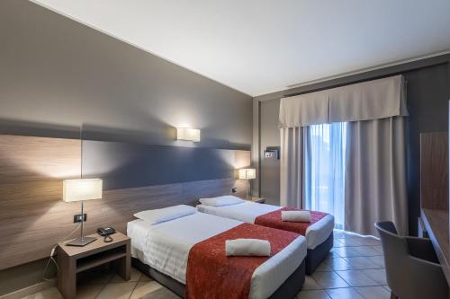米兰太阳花酒店的酒店客房设有两张床和窗户。