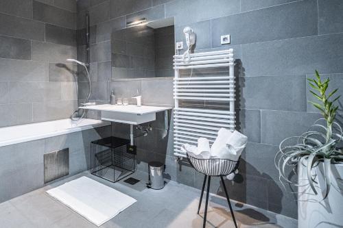 VipolžeVila Vipolže - Rooms & J. Suites的浴室配有盥洗盆、镜子和浴缸
