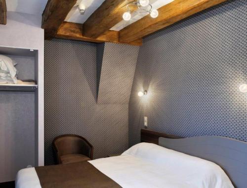 朗热Logis Hôtel Auberge de la Bonde的一间卧室设有一张床铺、一张桌子和天花板