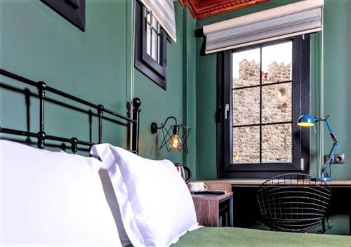 马尔马里斯Sunset Boutique Hotel Marmaris的一间卧室设有绿色的墙壁、一张床和窗户