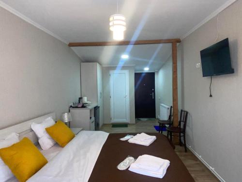 博尔若米Jorjadze street 23的一间卧室配有一张带黄色枕头的床和电视。