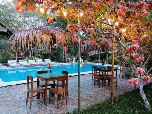 马尔多纳多港La Habana Amazon Reserve的游泳池旁的草伞下的桌椅