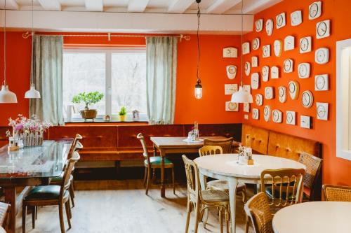 圣沃尔夫冈Das Franzl - Bett & Brot的餐厅拥有橙色的墙壁和桌椅