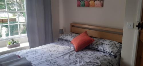 特鲁罗Penbetha House B&B的一间卧室配有一张带橙色枕头的床