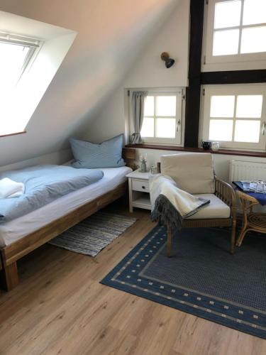 RöhrsenAltes Backhaus Bauernhof Vogel的一间卧室配有一张床、一把椅子和窗户。