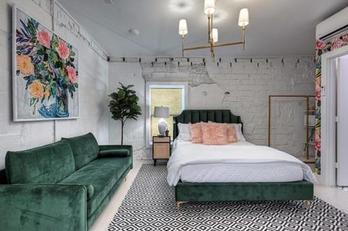 加尔维斯敦The Oleander Hotel Room Number 3的一间卧室配有一张床和一张绿色沙发