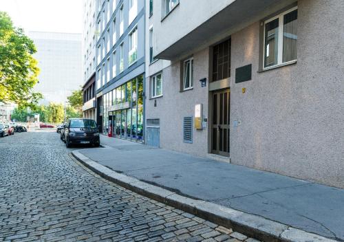 维也纳格西勒博士公寓酒店的停在大楼旁的街道上的汽车