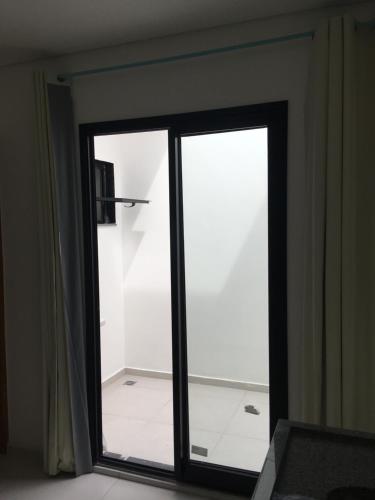 瓜鲁柳斯H34 Hotel的滑动玻璃门,位于带浴室的房间内