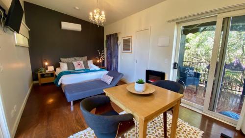 卡尔斯Phillip Island Nature Resort Villas的卧室配有一张床和一张桌子及椅子