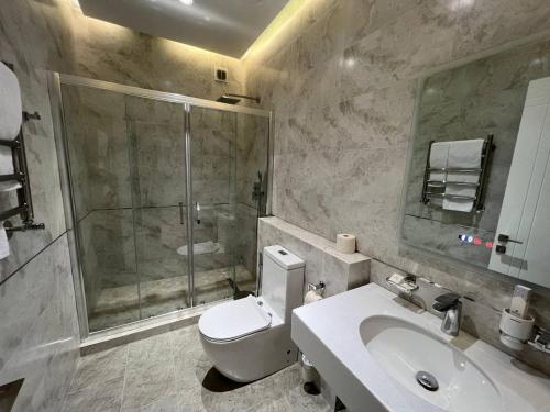 努库斯PANA HOTEL的带淋浴、卫生间和盥洗盆的浴室