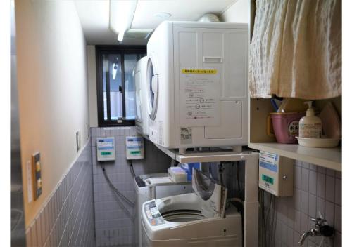 HachimanHotel Hachiman的洗衣房配有洗衣机和烘干机