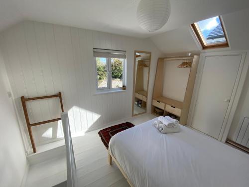 毛斯尔Cheerful one bedroom cottage in Mousehole.的卧室配有白色的床和窗户。