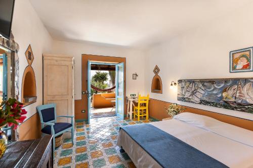圣马里纳萨利纳玛玛桑堤娜酒店的酒店客房带一张床、一张桌子和椅子