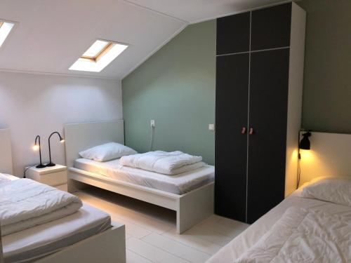 比伦Naar Zee op Ameland的一间卧室设有两张床和天窗