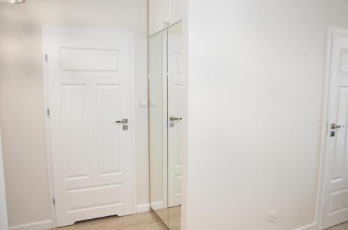 科沃布热格Apartament Luna Baltic Marina Residence的配有白色门和镜子的衣柜