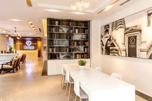 胡志明市Calista Sai Gon Hotel的一间配备有白色桌椅的用餐室