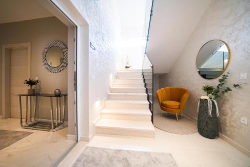 Donji ZemunikD-Palace Apartments-Olive tree的楼梯,有镜子和椅子