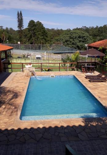 阿蒂巴亚Chácara Canto Verde Atibaia的庭院里的一个蓝色海水大型游泳池