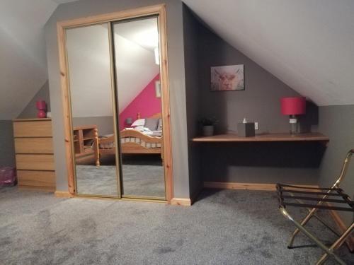 伊文格瑞Corrie View的阁楼间设有镜子和一张床