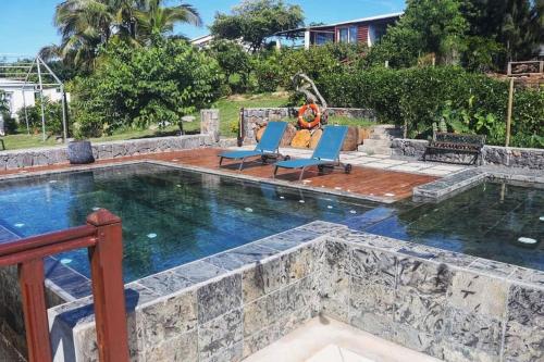 Rodrigues Island弗欧萨法特山林小屋的一个带2把躺椅的游泳池和一个游泳池