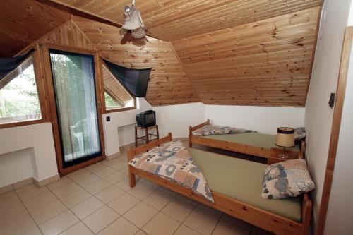 雷夫菲勒普Vöröskő apartmanház的小屋内设有一间带两张床和一台电视的卧室