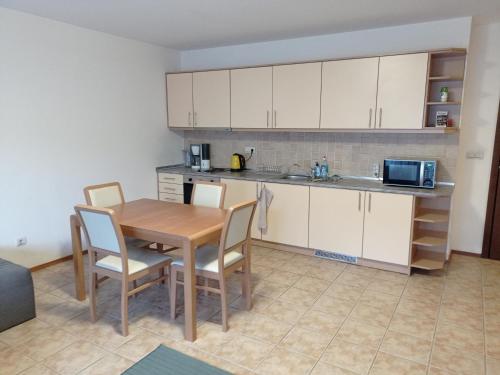 班斯科Free SPA Pirin lodge cosy apartment的厨房配有桌椅和微波炉。