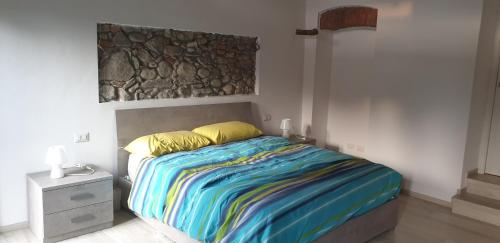 TravedonaCASA DEL LAGO的一间卧室配有一张带彩色毯子的床